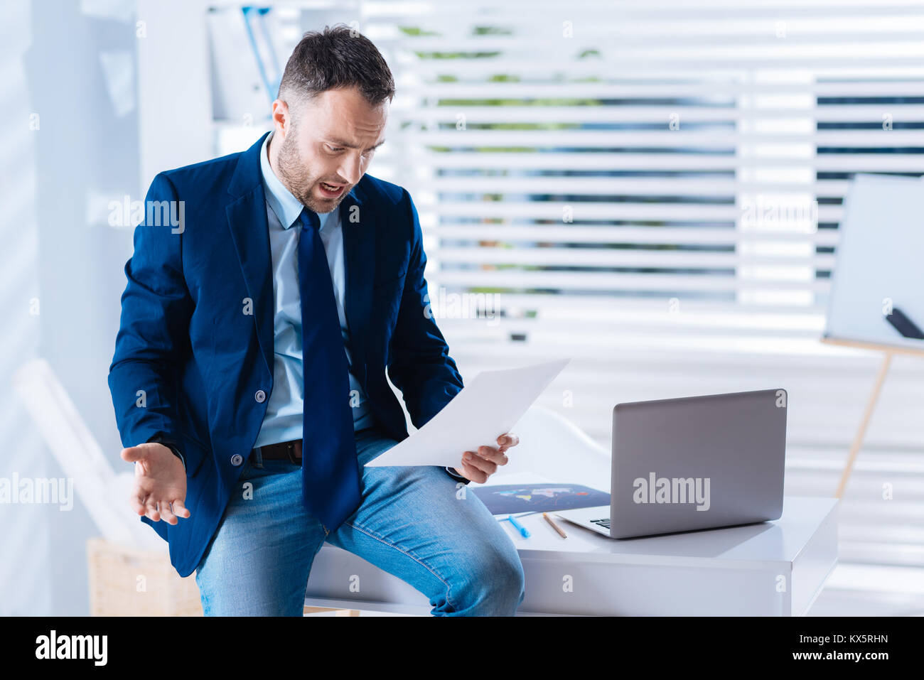 Outraged man looking at the documents after being dismissed from work Stock Photo