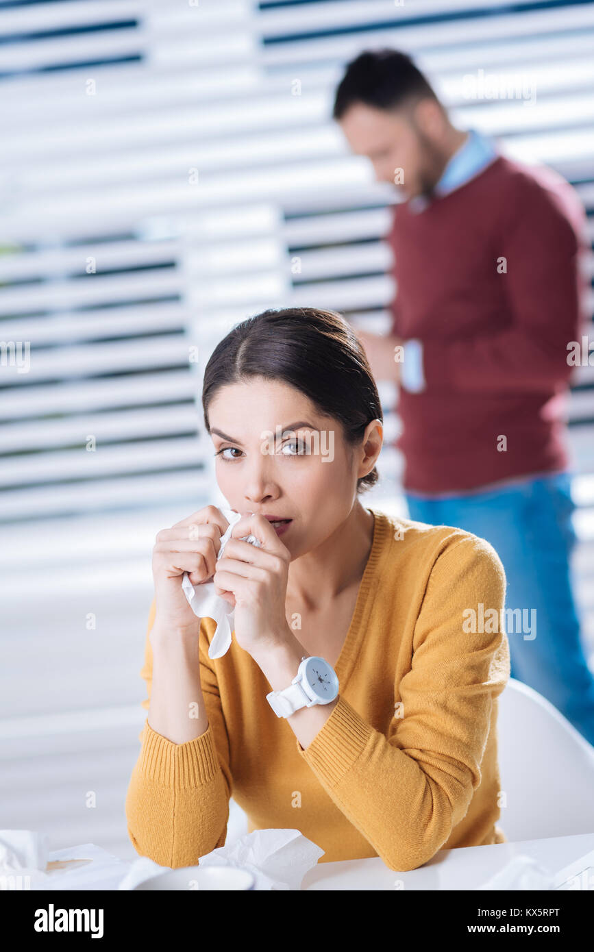 Unhappy woman holding a napkin while having a running nose Stock Photo