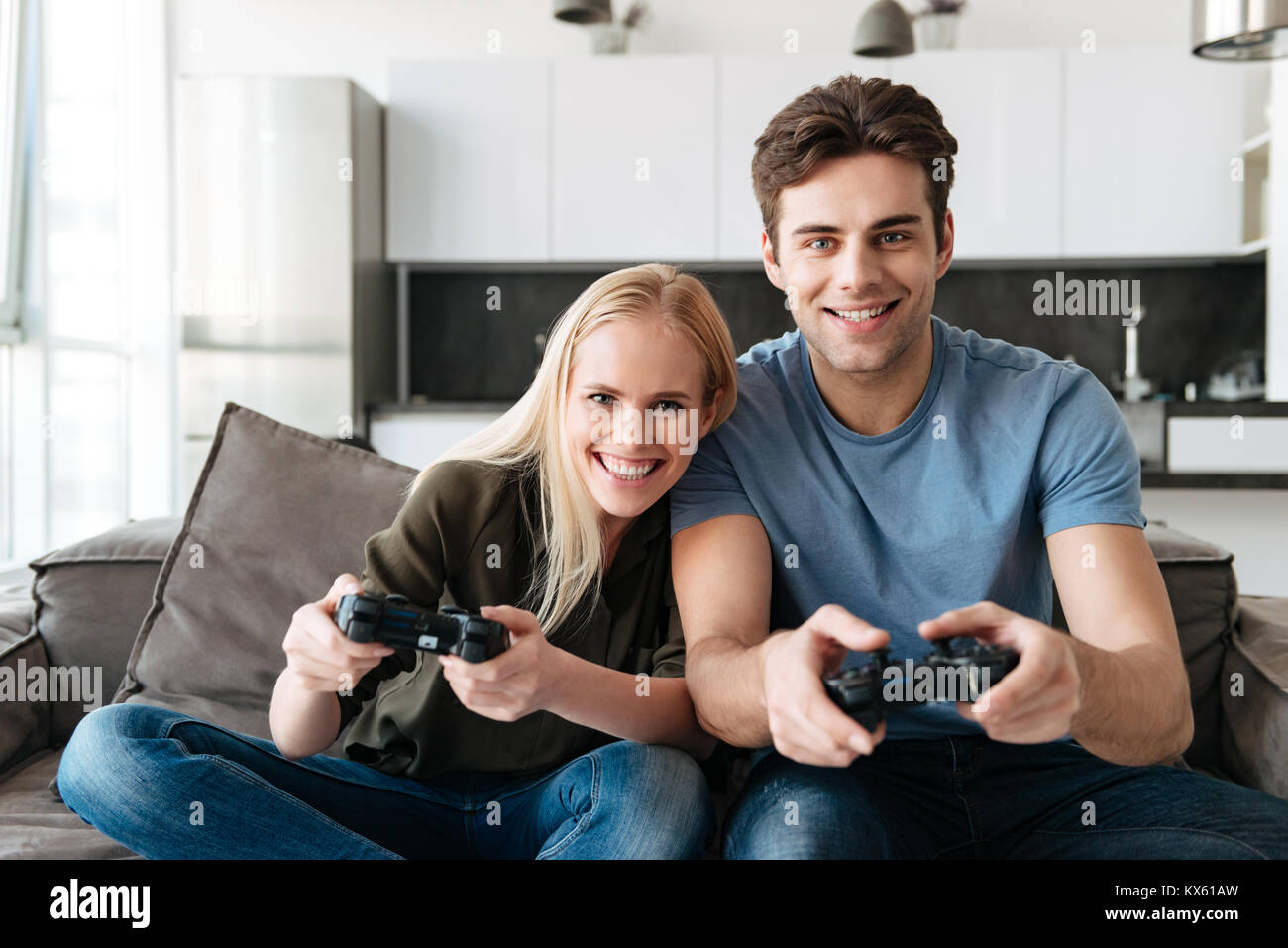 Cheerful boyfriend and girlfriend playing video games to win. Happy couple  using controller to play online game and winning gameplay on console.  People holding joystick to have fun Stock Photo - Alamy