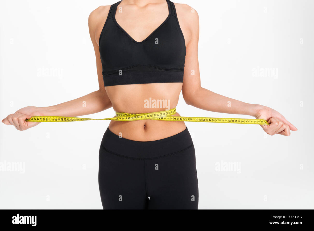 Close Up Of A Slim Woman Holding Measuring Tape Around Her Waist