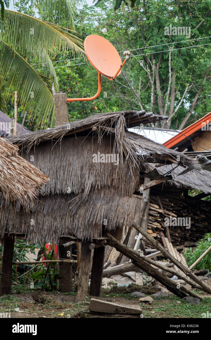 a modern satellite dish on the roof of shack in hmong village, Laos. Traditional house in the hmong tribe village. Stock Photo