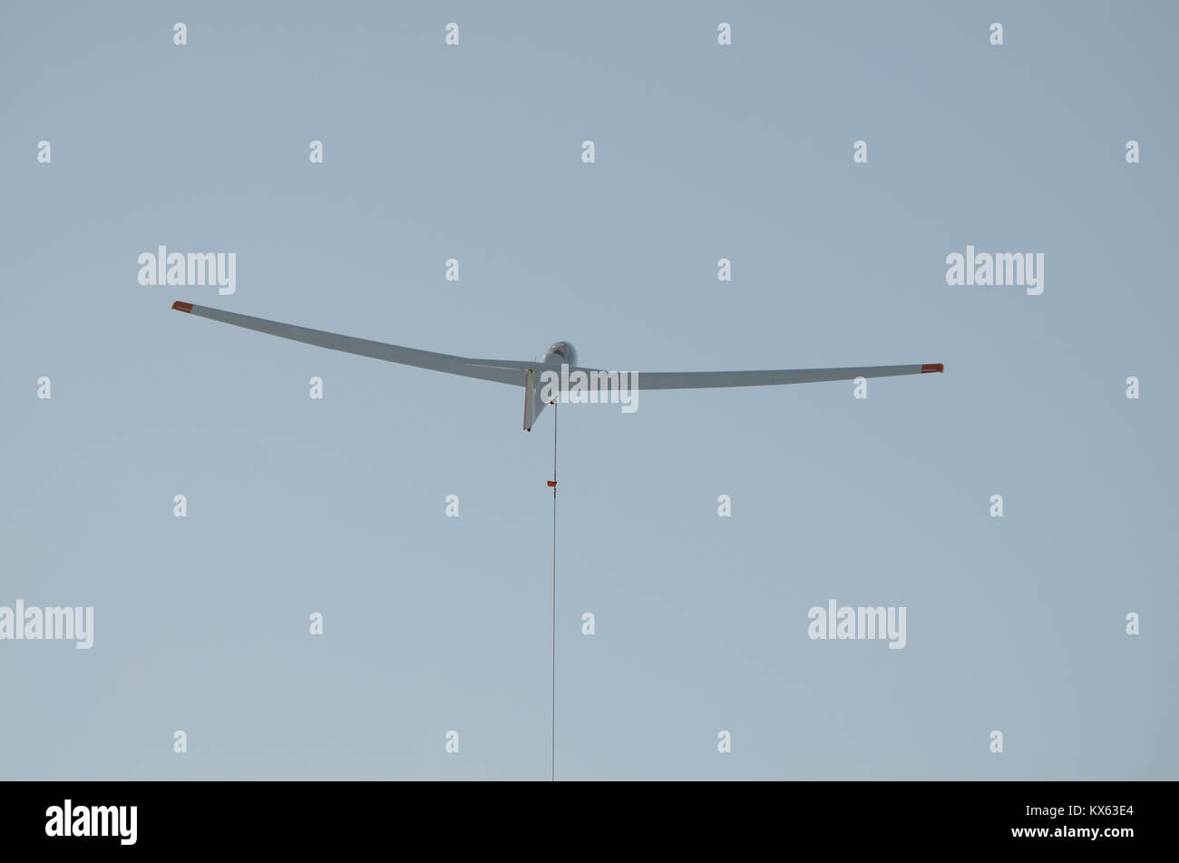 A glider is launched into the air by a winch cable, seen at the bottom