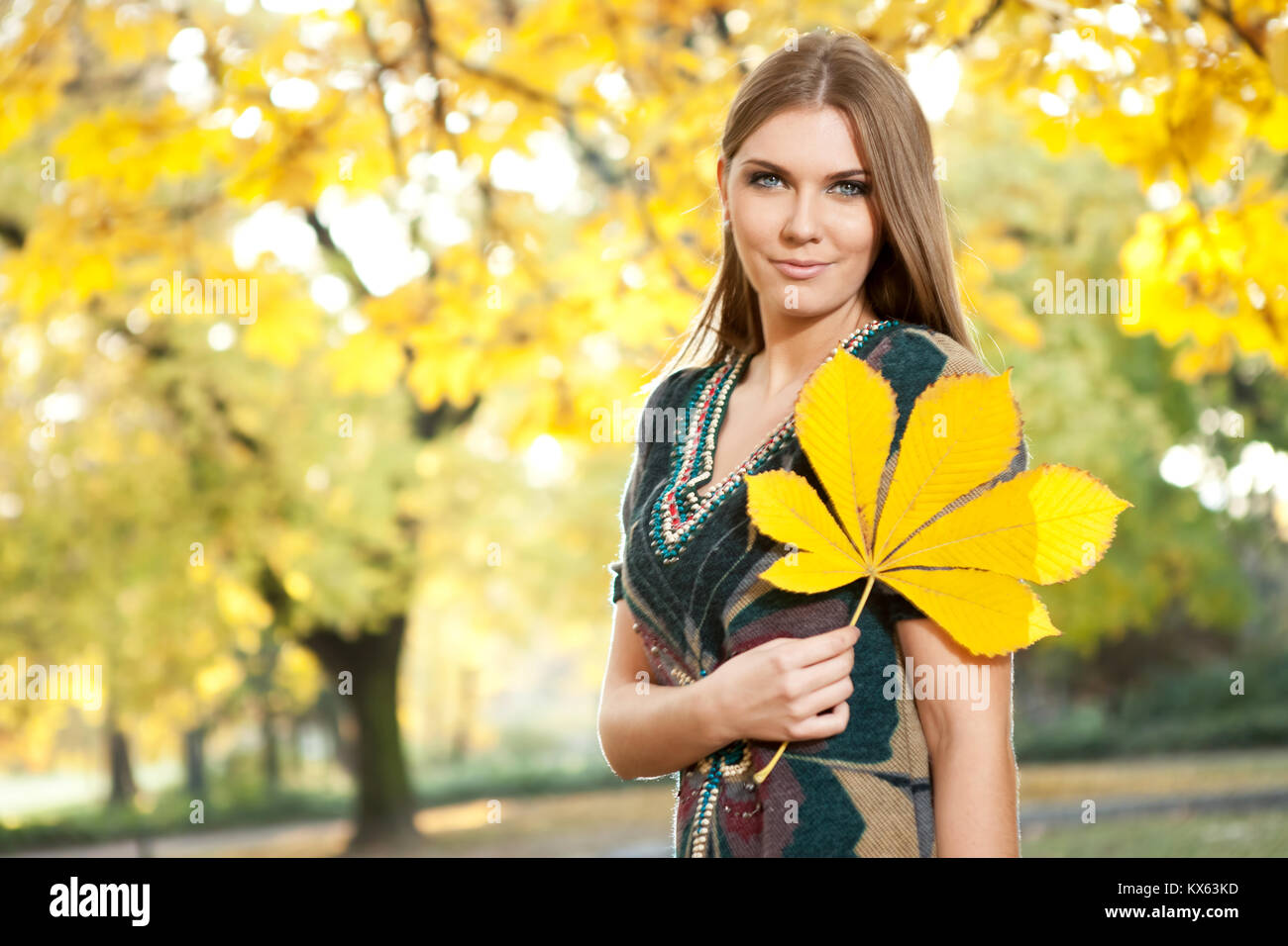 autumn beautiful girl holding big yellow leaf Stock Photo - Alamy