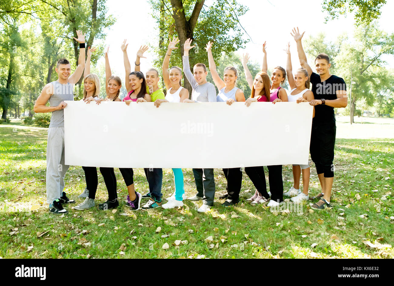 large group of young people holding a big white board Stock Photo - Alamy