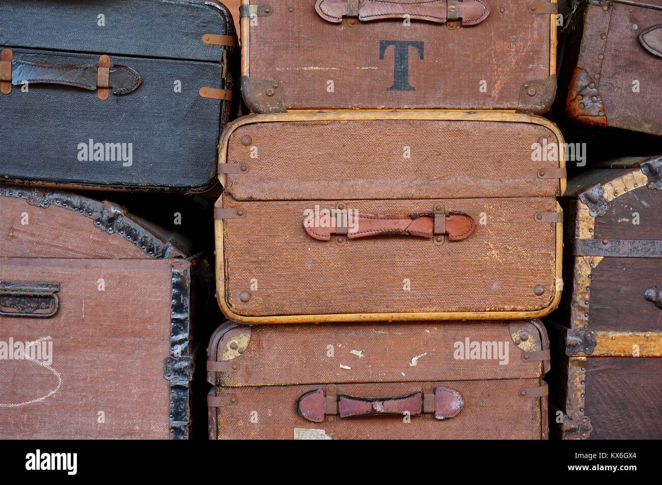 Black and brown vintage travel suitcases stacked on a railway trolley