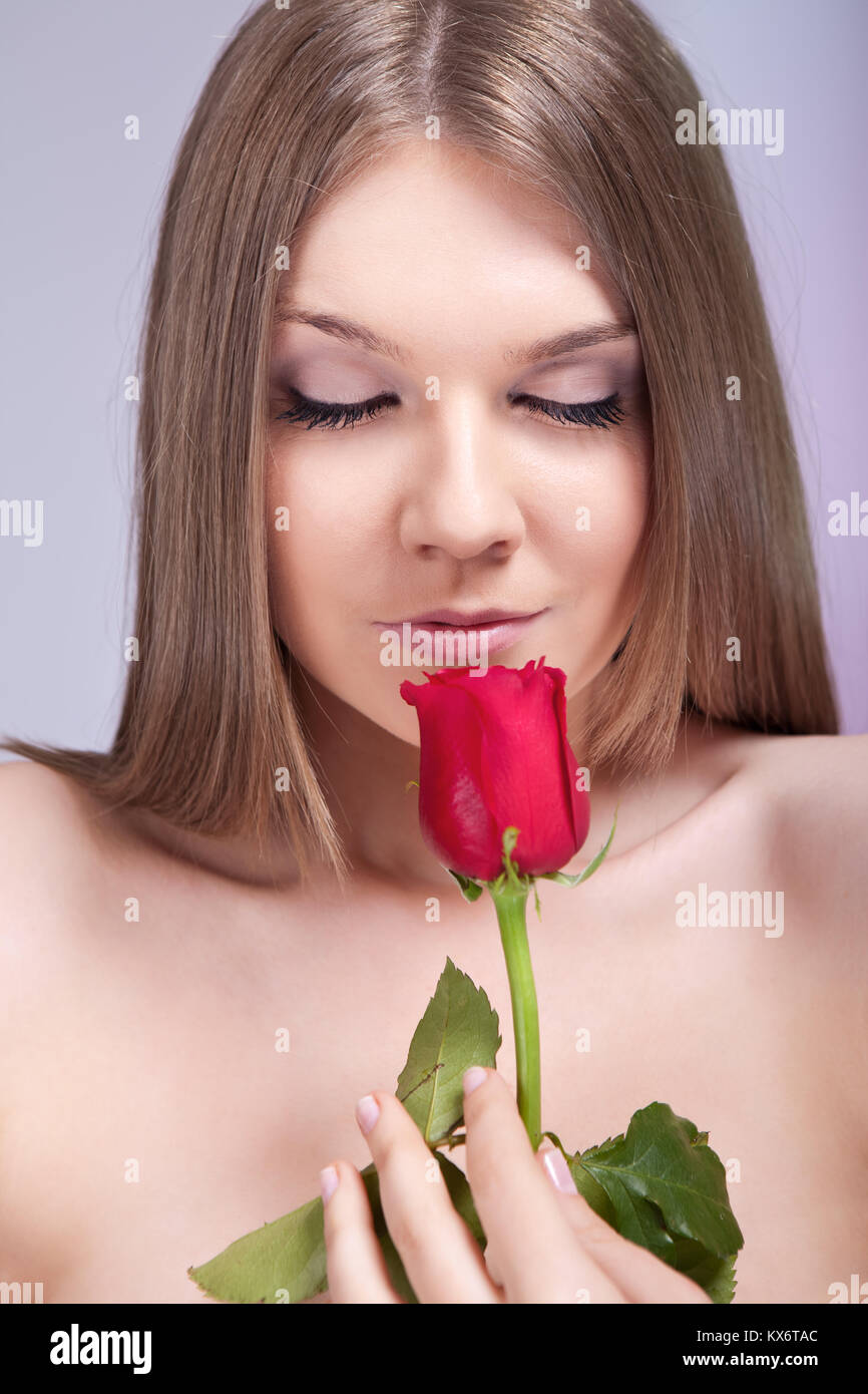 beauty young girl enjoying in smell of red rose Stock Photo - Alamy