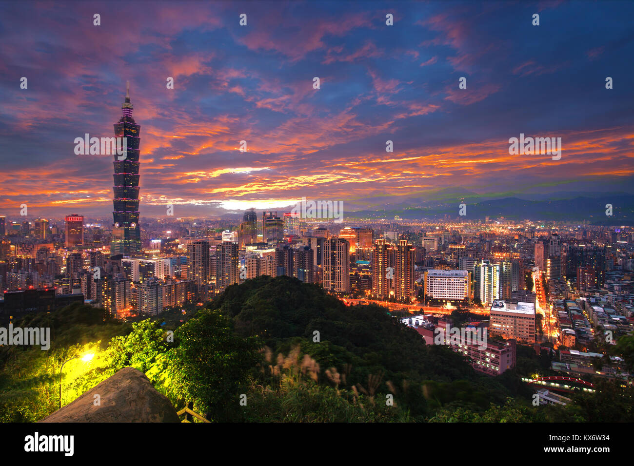 The Taipei 101 towers over the Xinyi District at twilight Stock Photo