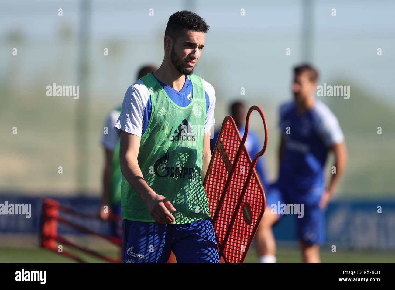 Schalke's Nabil Bentaleb carries a training dummy during a training