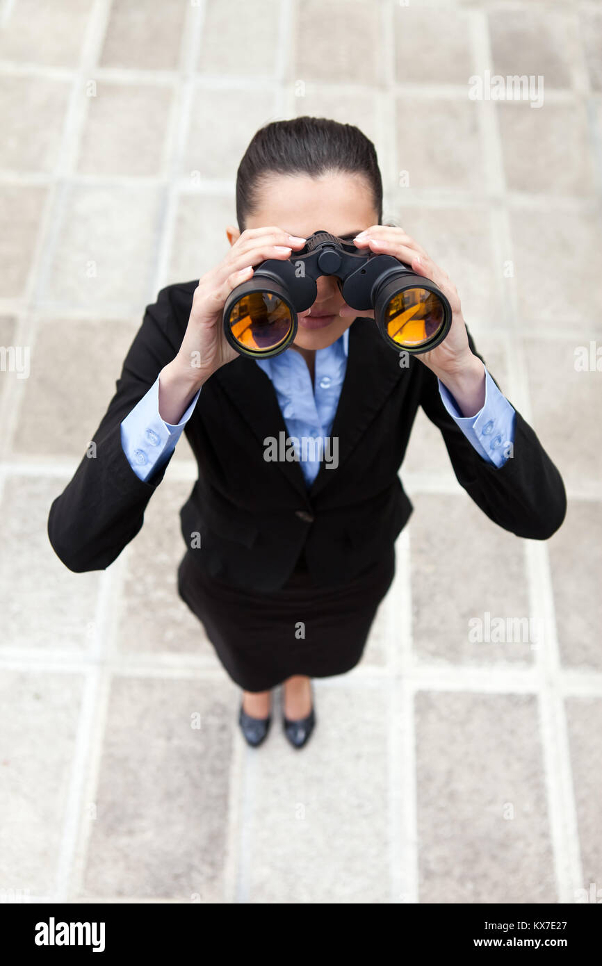 businesswoman with binocular standing outdoor, top view Stock Photo