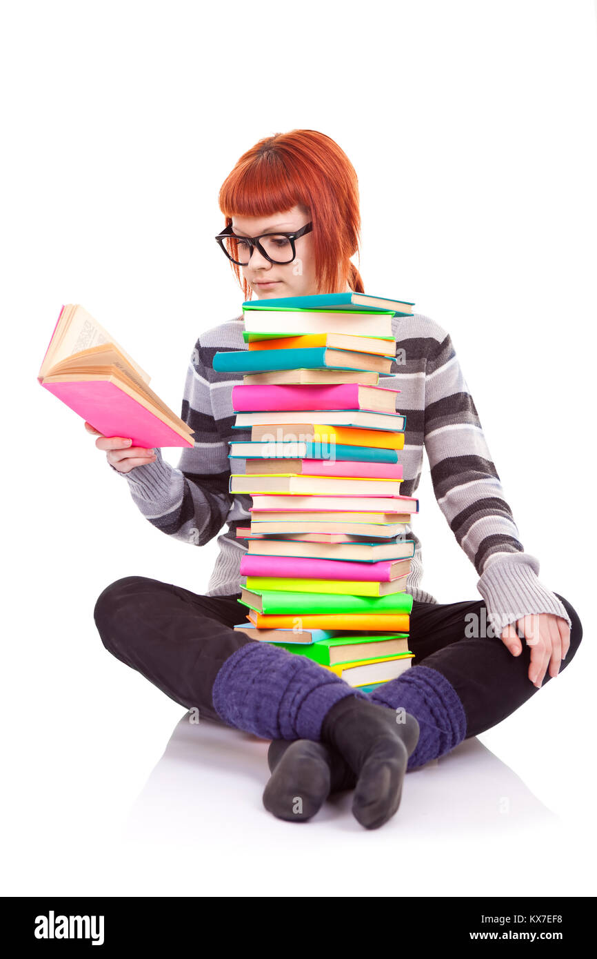 female student sitting with pile of books and reading book Stock Photo ...
