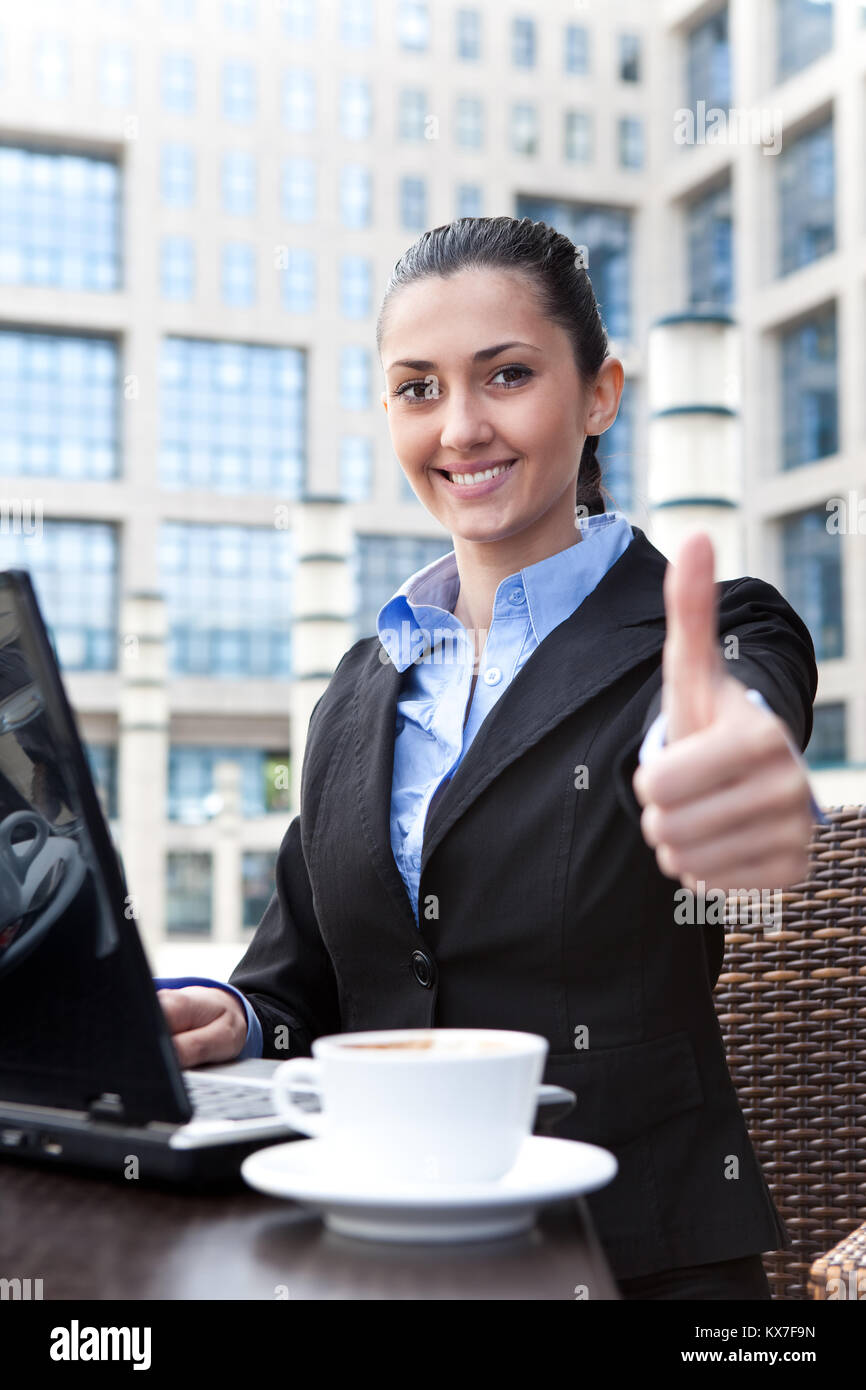 smiling business woman working on laptop and shoving thumbs up Stock ...