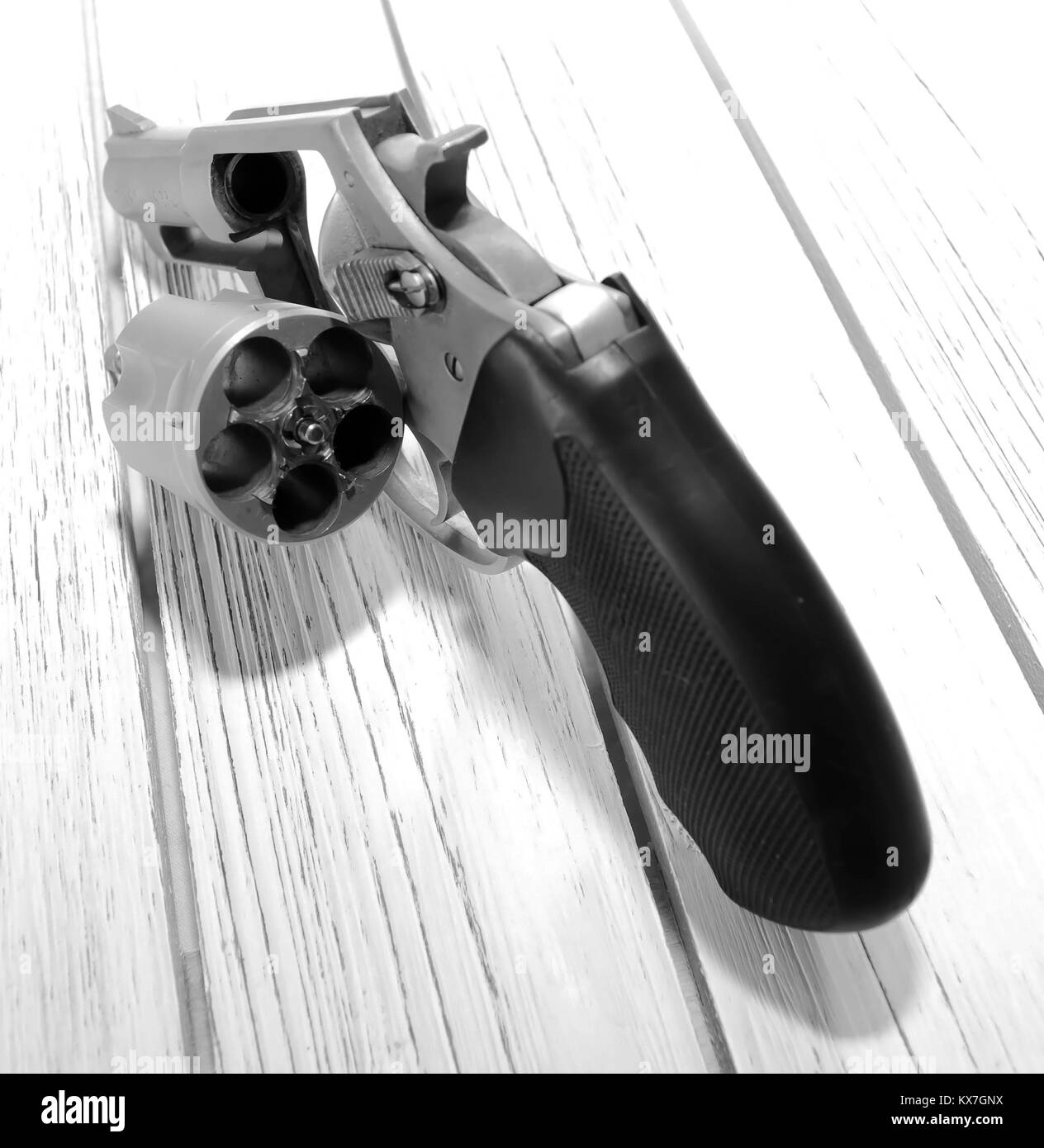 A stainless steel unloaded revolver on a wooden table with it's ...