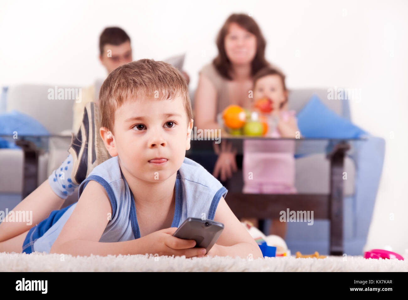 happy family in living room, son on floor watching TV Stock Photo