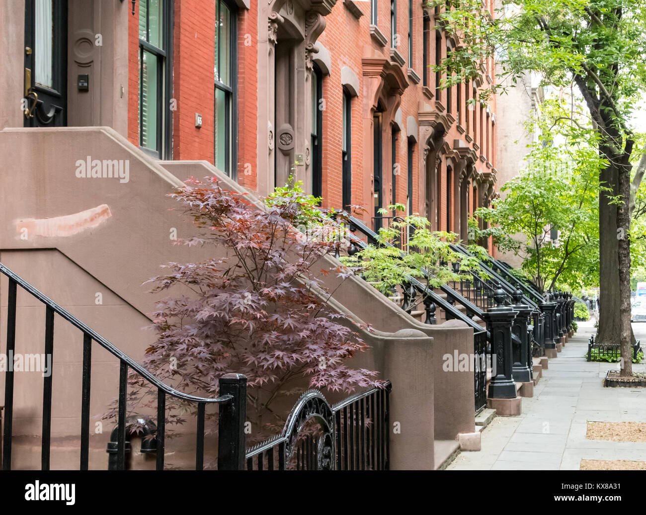 Quiet neighborhood street sidewalk lined with historic brownstone