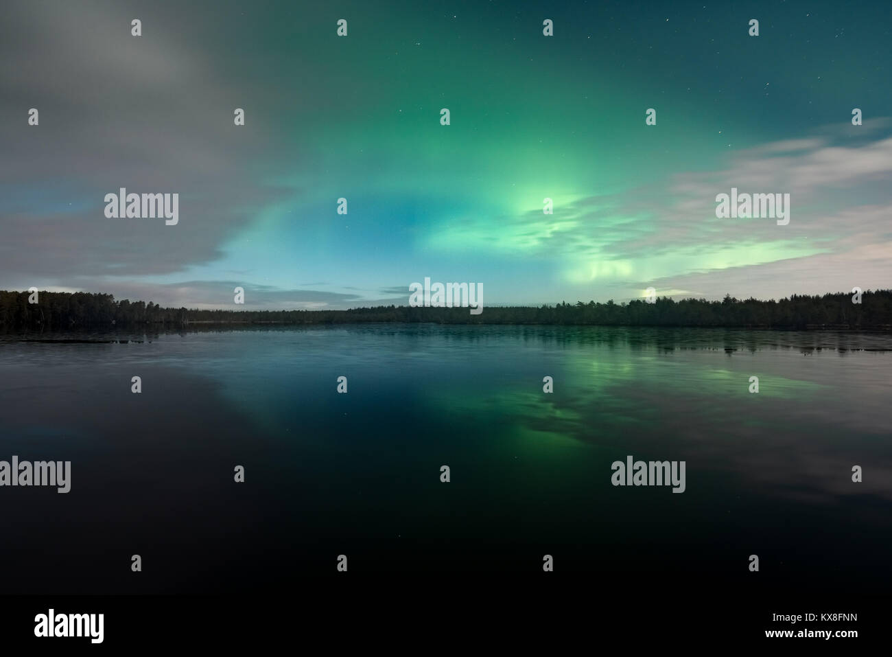 Northern Lights behind fast moving clouds in Kurjenrahka National Park, Finland Stock Photo