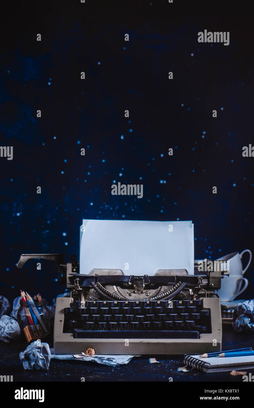 Modern typewriter with sheets of paper, empty coffee cups, pencils and  notepads on a dark background. Editing and copywriting workplace. Creative  writing concept Stock Photo - Alamy