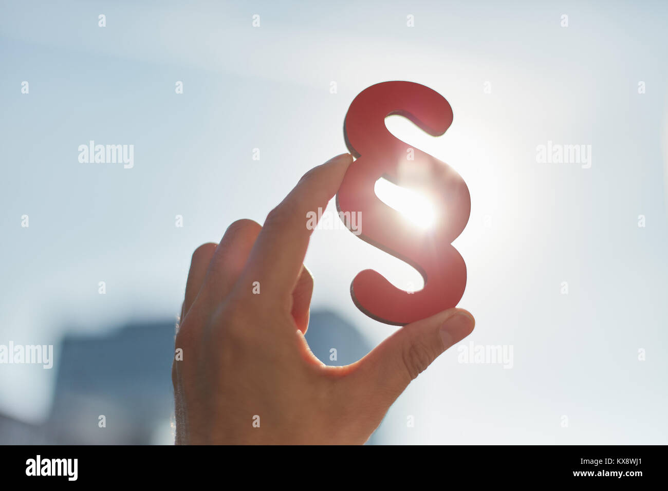 Hand holds paragraphs in the sun as a sign of justice and justice Stock Photo