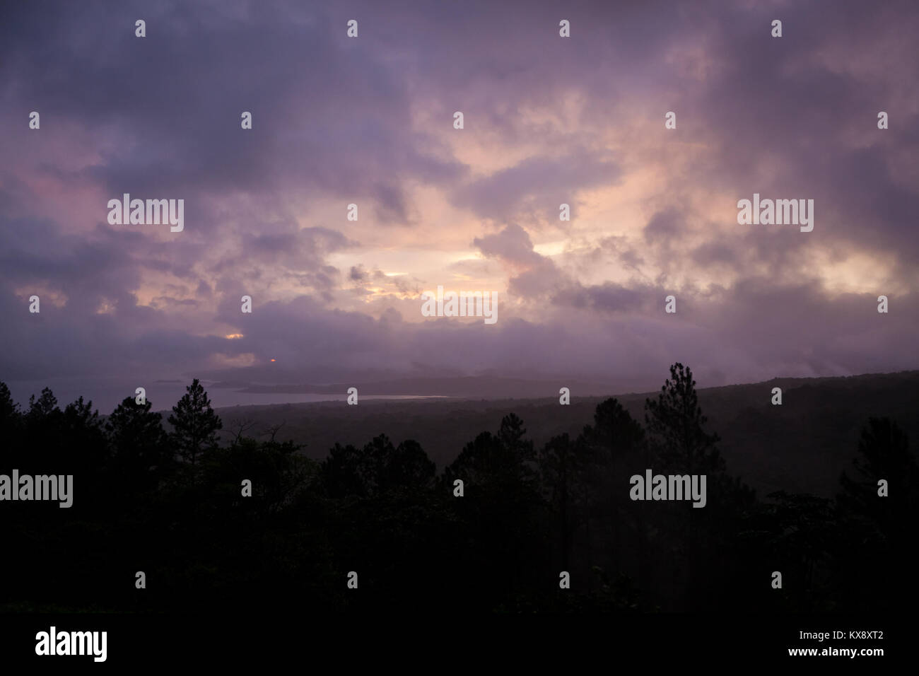 Cloudy sunset and forest landscape Stock Photo - Alamy