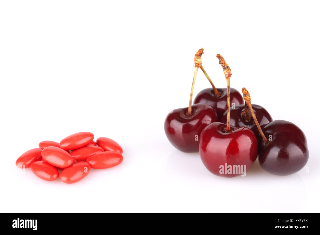 Fruits or drugs are better? Fresh cherry and medicine pills Stock Photo