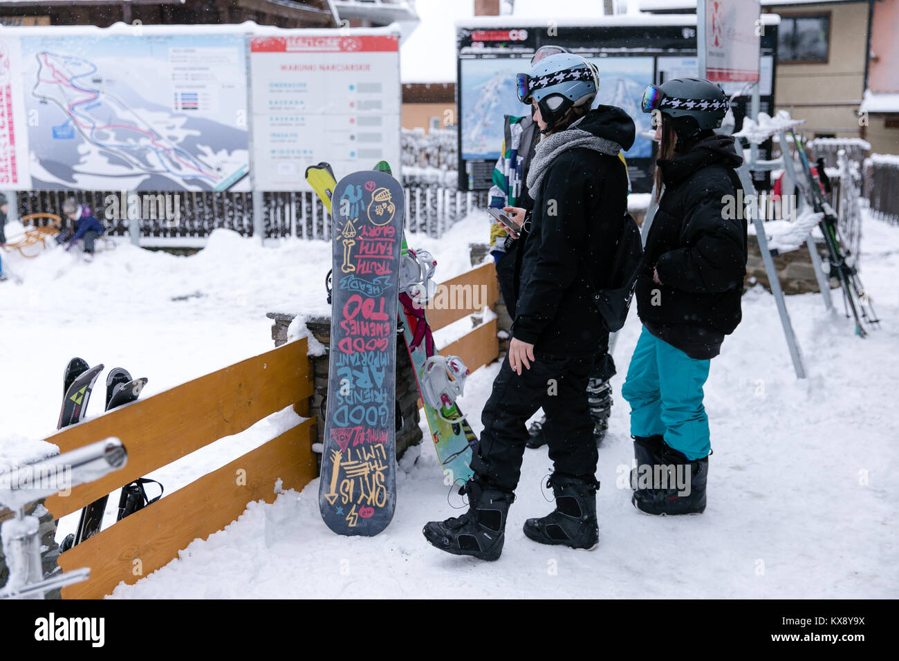 A group of snowboarders standing by their snowboards waiting for their friends in covered in snow Szczyrk Poland Stock Photo
