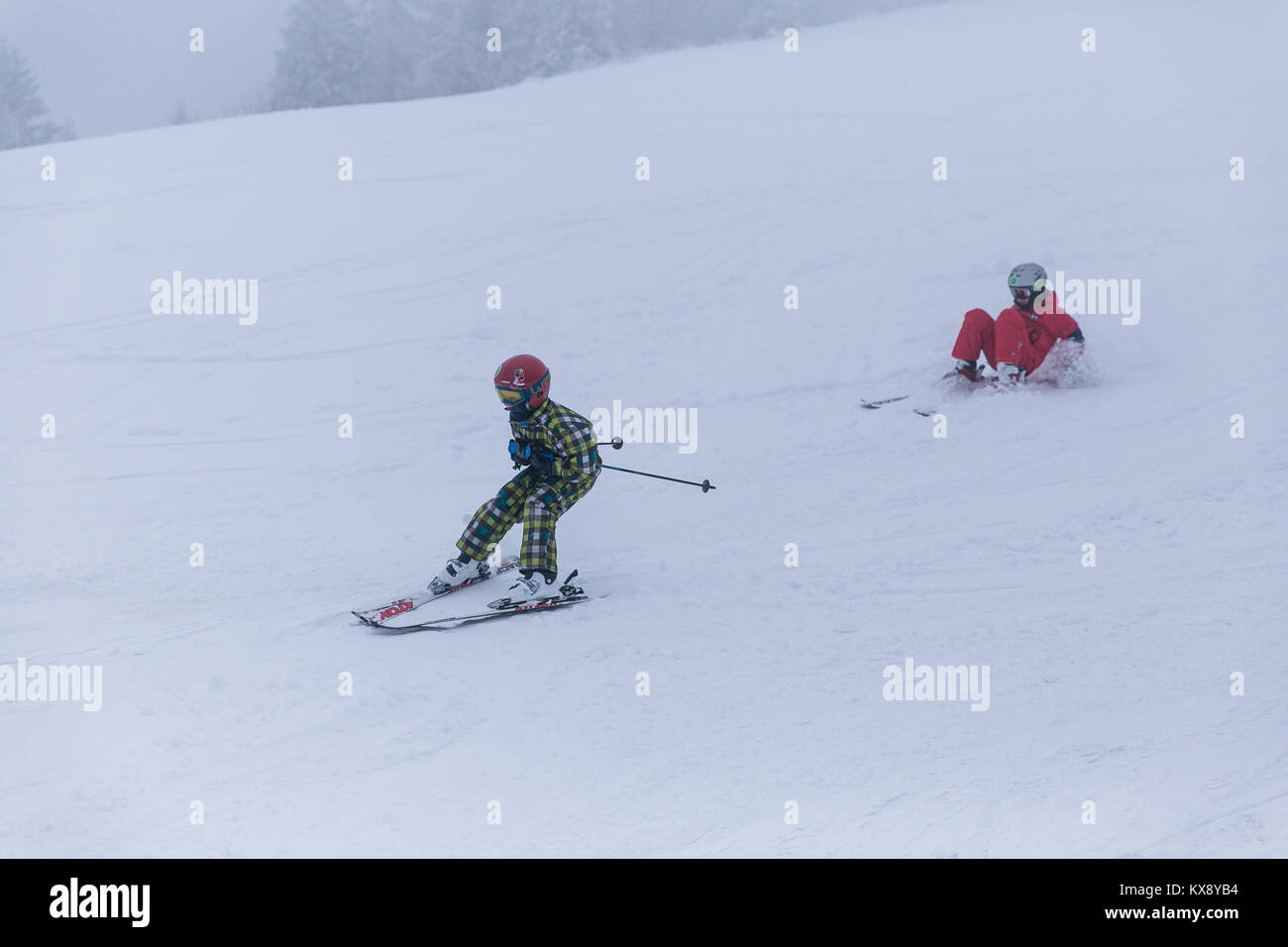 Kids skiing and having fun on the slopes of covered in snow and mist Skrzyczne mountain in Szczyrk one of the Polish Crown Peaks in Silesian Beskid Stock Photo