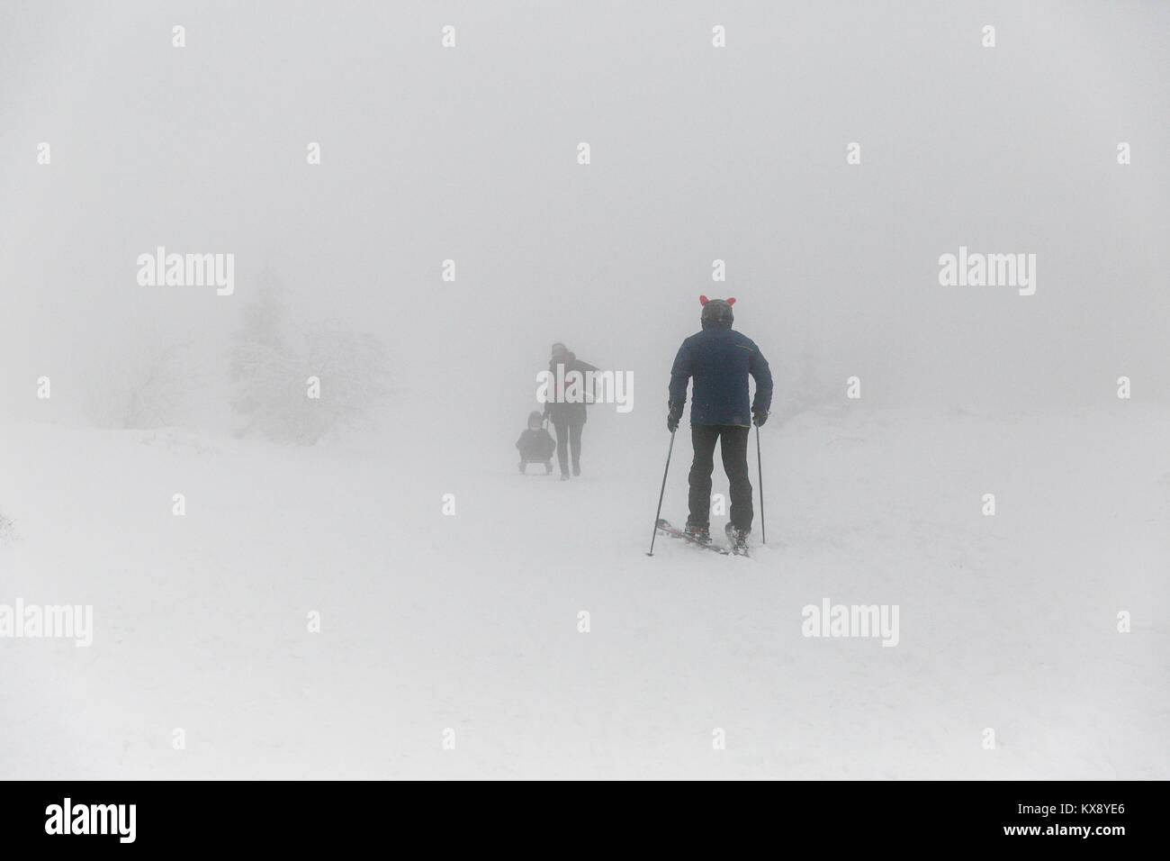 Skiers and hikers at the covered in snow and mist summit of Skrzyczne mountain in Szczyrk Poland heading for the slopes and hiking trails Stock Photo