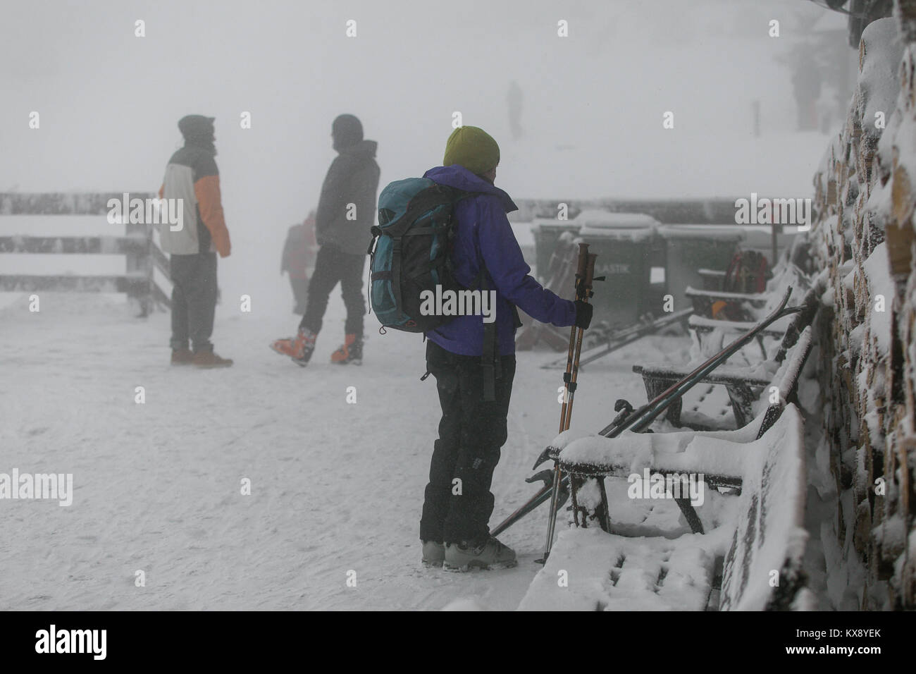 Skiers snowboarders and hikers arriving at covered in snow and mist summit of Skrzyczne mountain in Szczyrk heading for the slopes and hiking trails Stock Photo