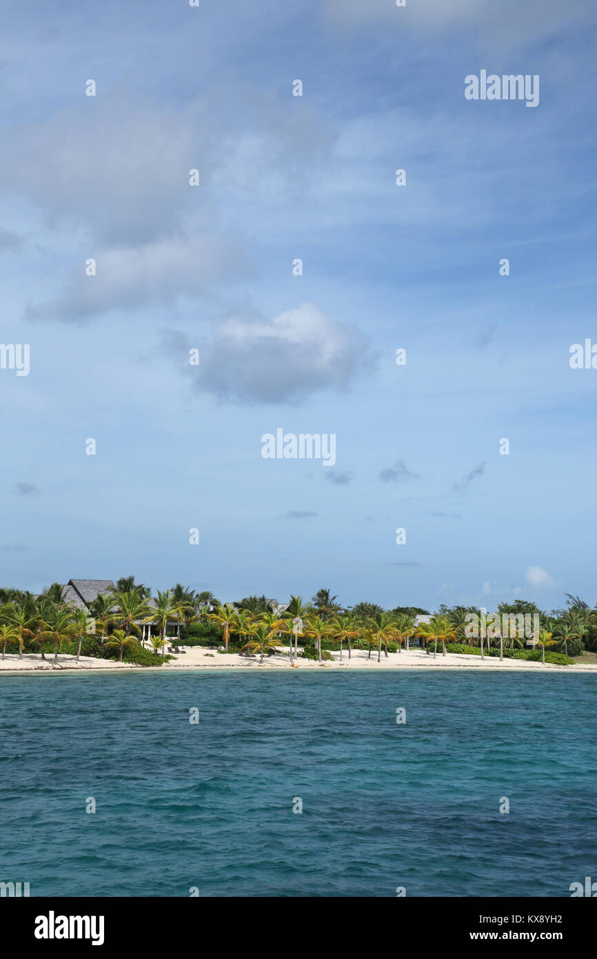 Beautiful tropical beach with turquiose sea & white sand on Green Island, Antigua, Caribbean. Vertical with copy space. Stock Photo