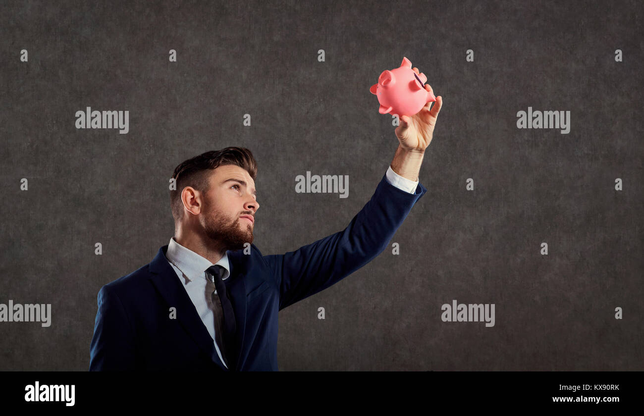 A man in a suit with a piggy bank Stock Photo - Alamy