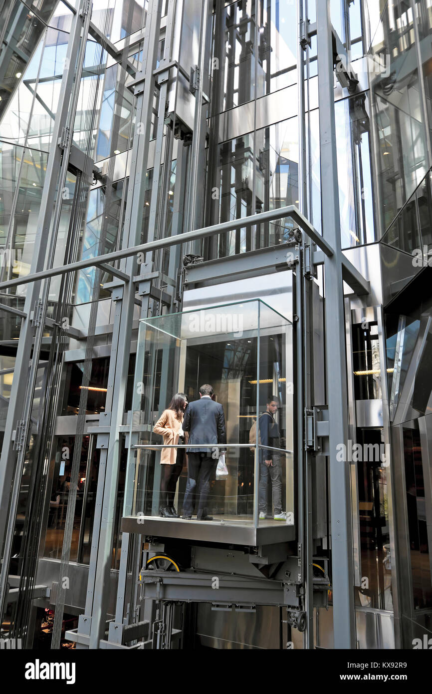 Business people standing inside the lift capsule outside One New Change shopping centre modern building in Central London England UK   KATHY DEWITT Stock Photo
