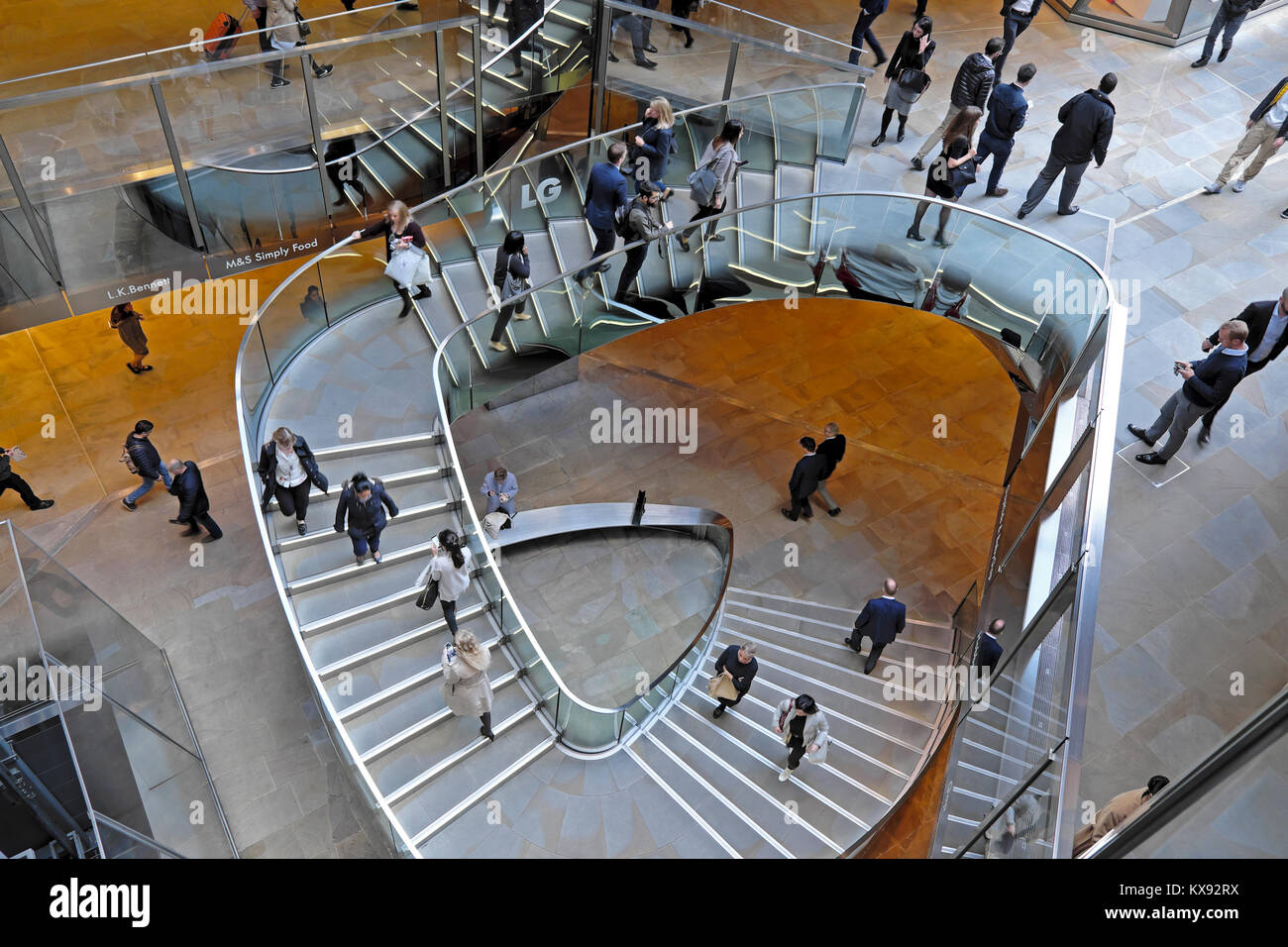 Overhead view looking down on people walking on stairway inside the shopping centre at One New Change in Central London UK.  KATHY DEWITT Stock Photo
