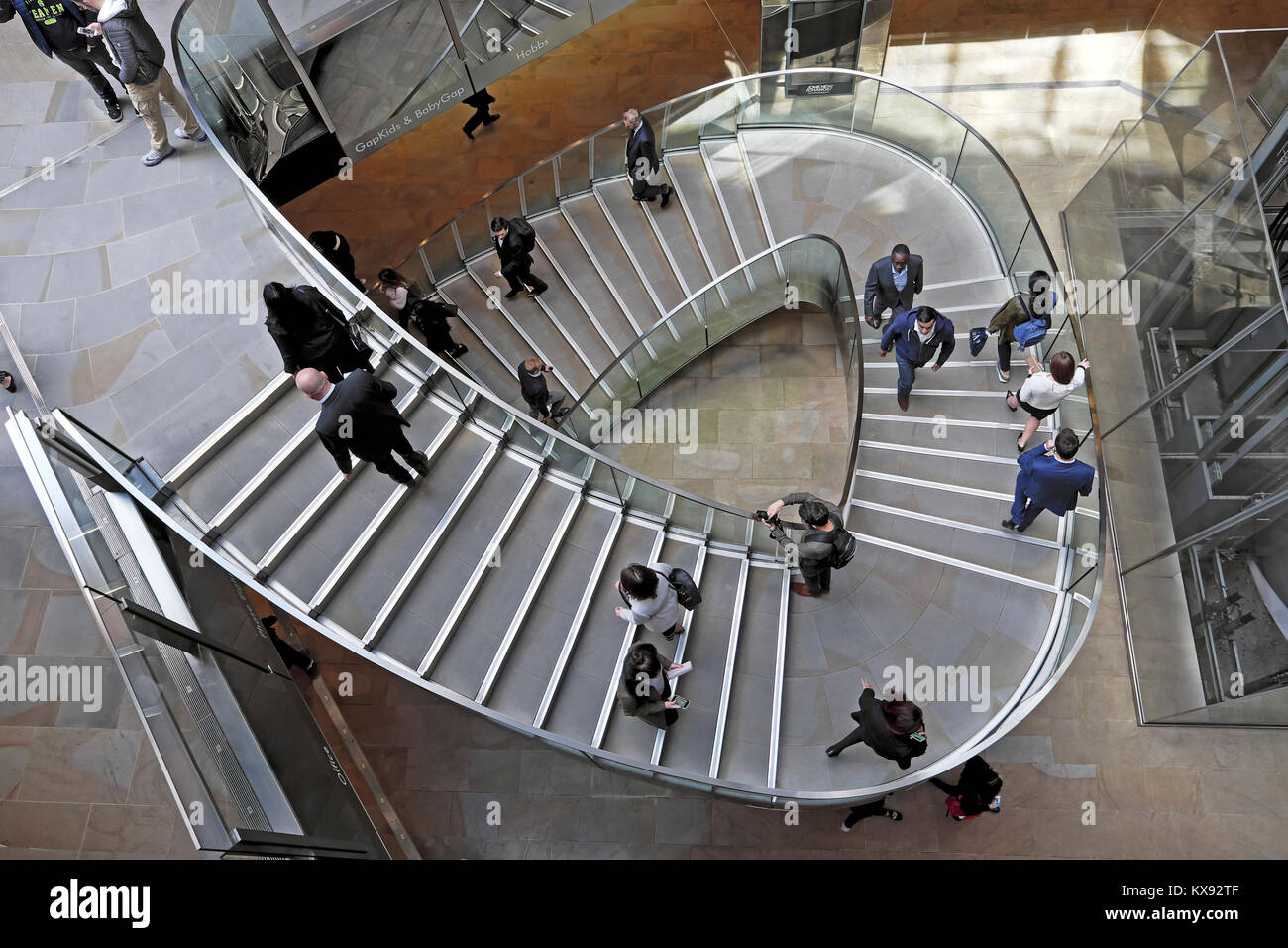 Overhead view looking down on people walking on stairway staircase inside the shopping centre at One New Change in Central London UK.  KATHY DEWITT Stock Photo
