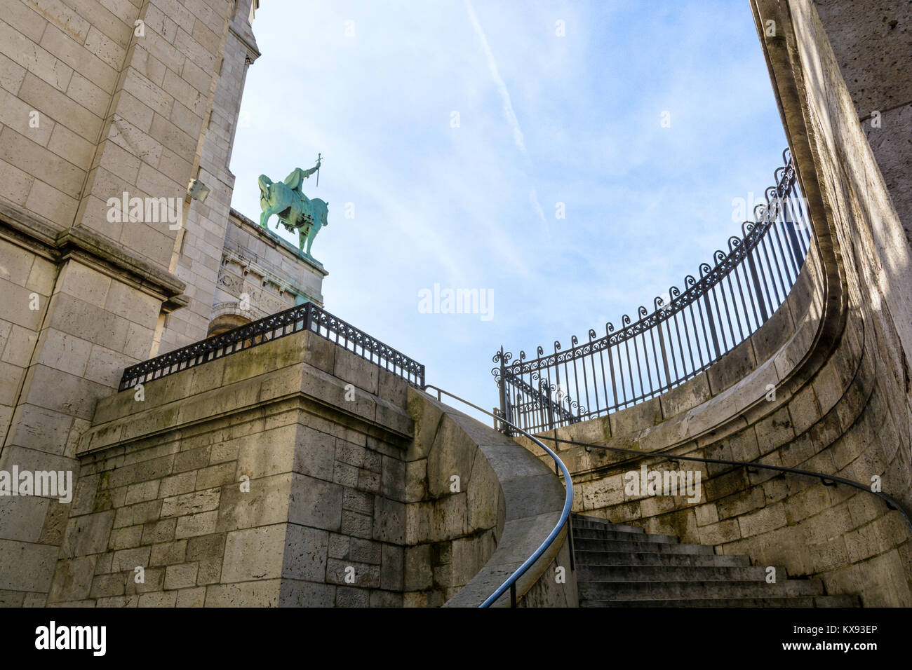 Low angle view of the equestrian statue of King Saint-Louis overhanging the portico of the Basilica of the Sacred Heart of Paris with a solid stone st Stock Photo