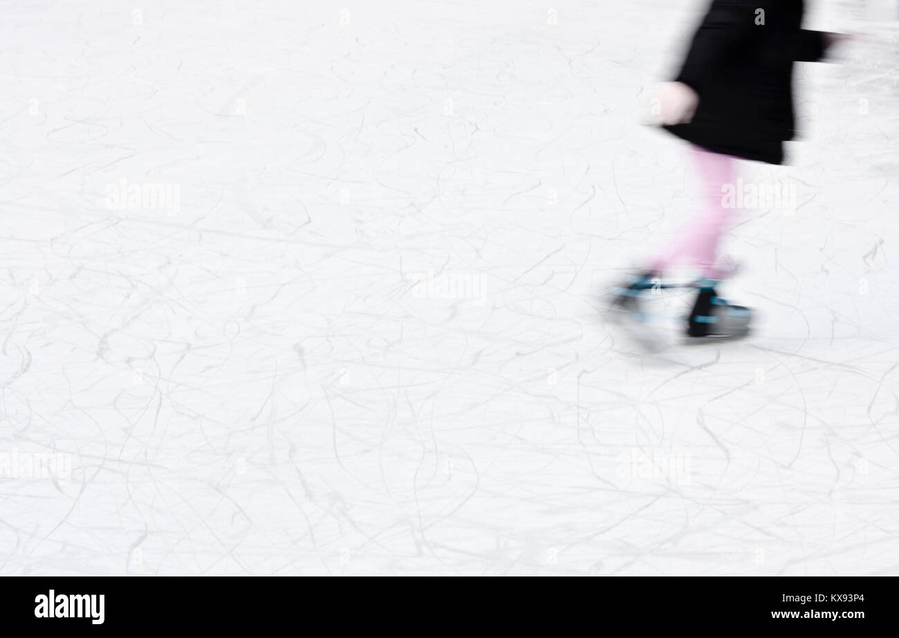 Arty blurry girl ice skating for fun and winter recreation Stock Photo