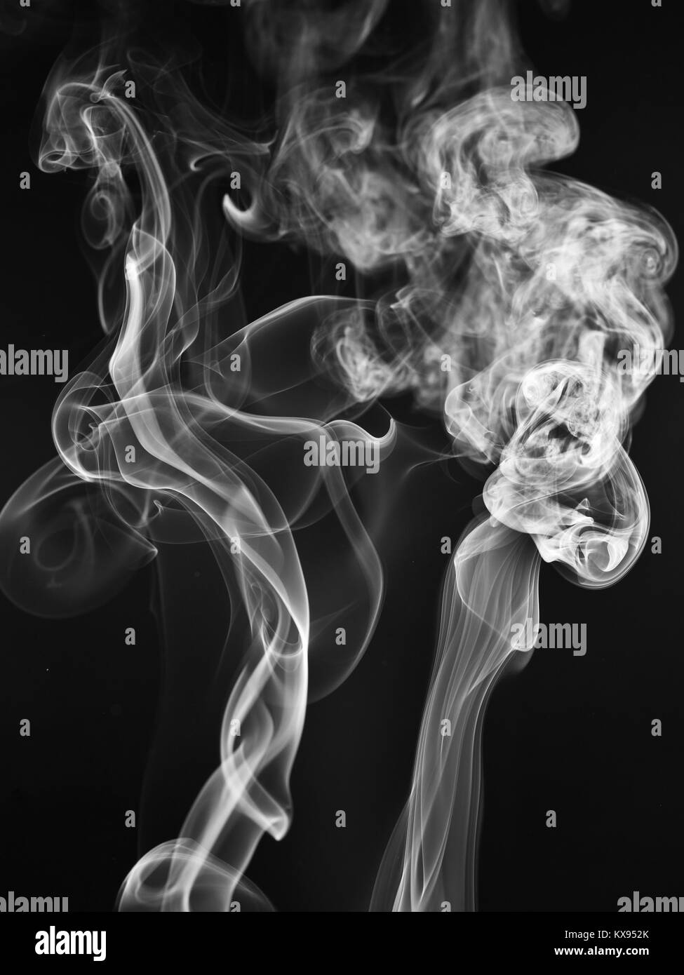 A whisp of white smoke against the black background Stock Photo