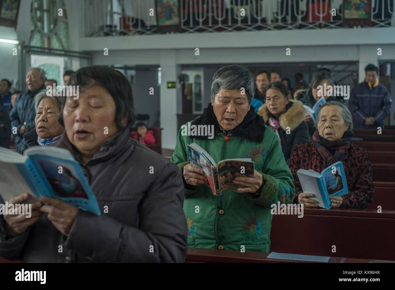 Believers sing Mass songs during Christmas Mass at Sacred Heart of Jesus Church in Housangyu village, 70 kilometers west of Beijing center, one of the earliest churches in China. 25-Dec-2017 Stock Photo
