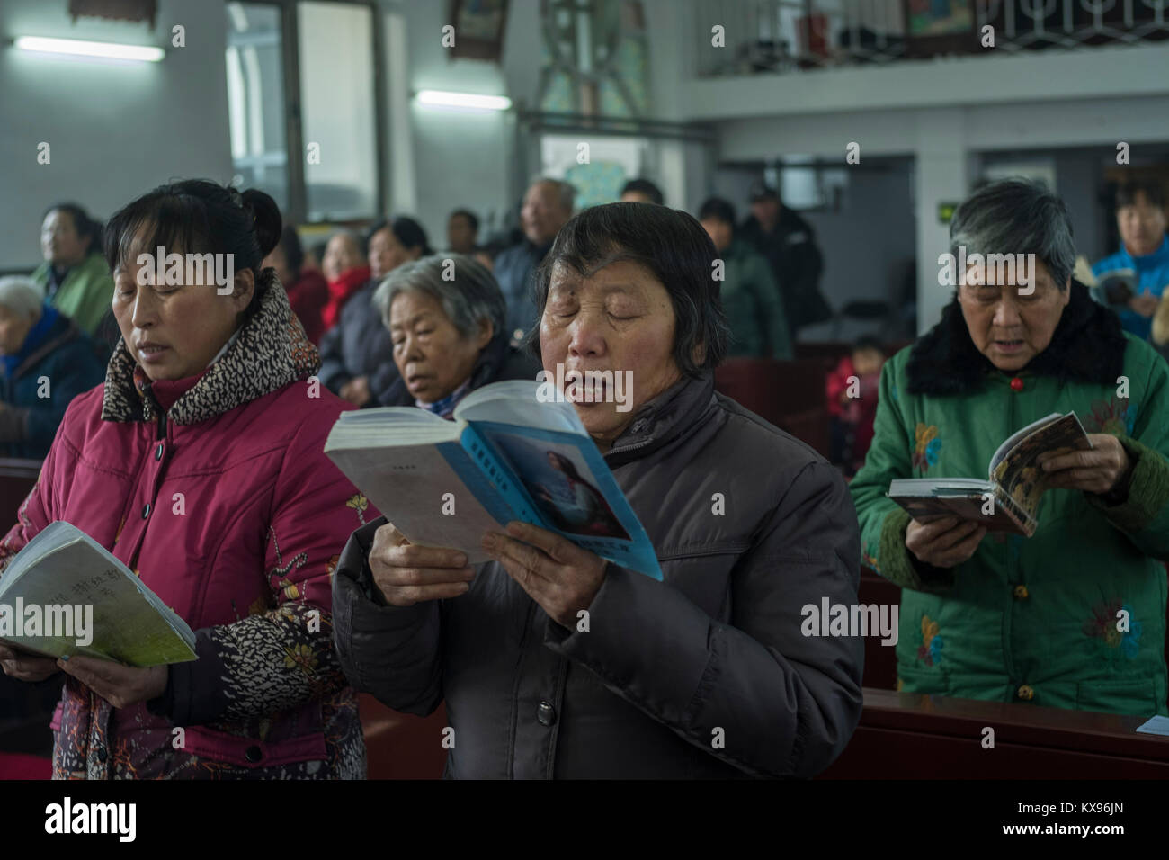 Believers sing Mass songs during Christmas Mass at Sacred Heart of Jesus Church in Housangyu village, 70 kilometers west of Beijing center, one of the earliest churches in China. 25-Dec-2017 Stock Photo