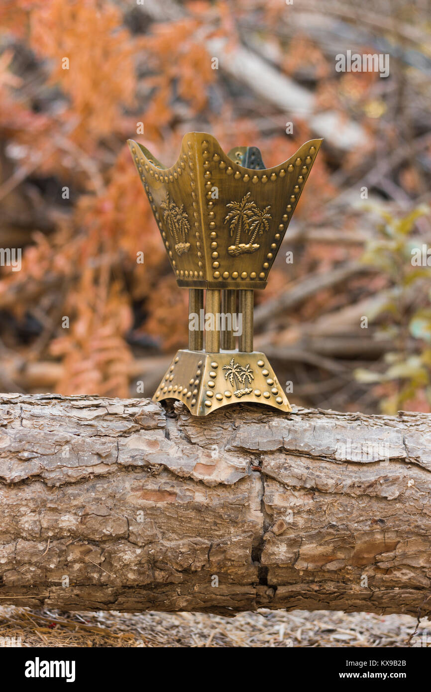Golden censer incense burner on a wood log in the woods Stock Photo Alamy