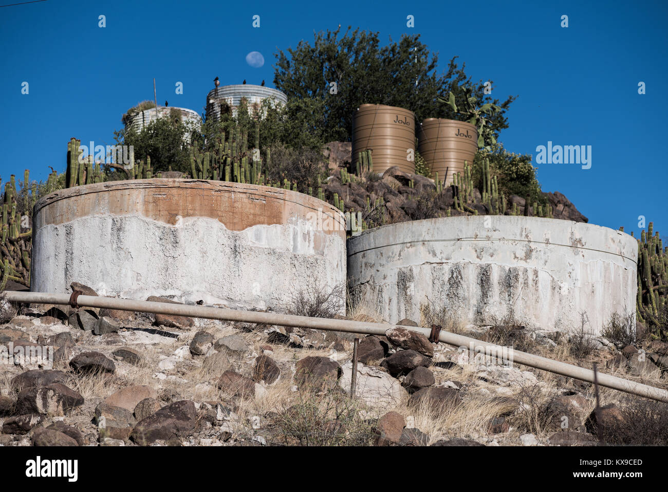 Water storage tanks from different generations for a gravity fed water system in the Northern Cape, South Africa Stock Photo