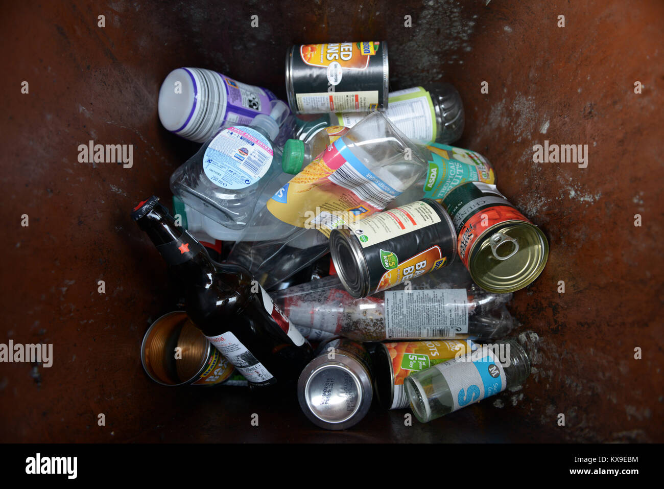 Plastic and glass bottles, glass jars and tin containers in a recyling bin. Stock Photo