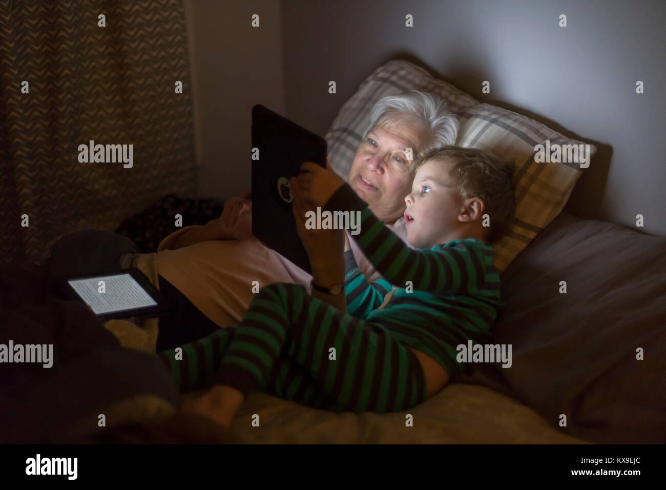 Wheat Ridge, Colorado - Susan Newell, 69, and her grandson, Adam Hjermstad Jr., 3, play an educational game on an iPad before bedtime. Stock Photo