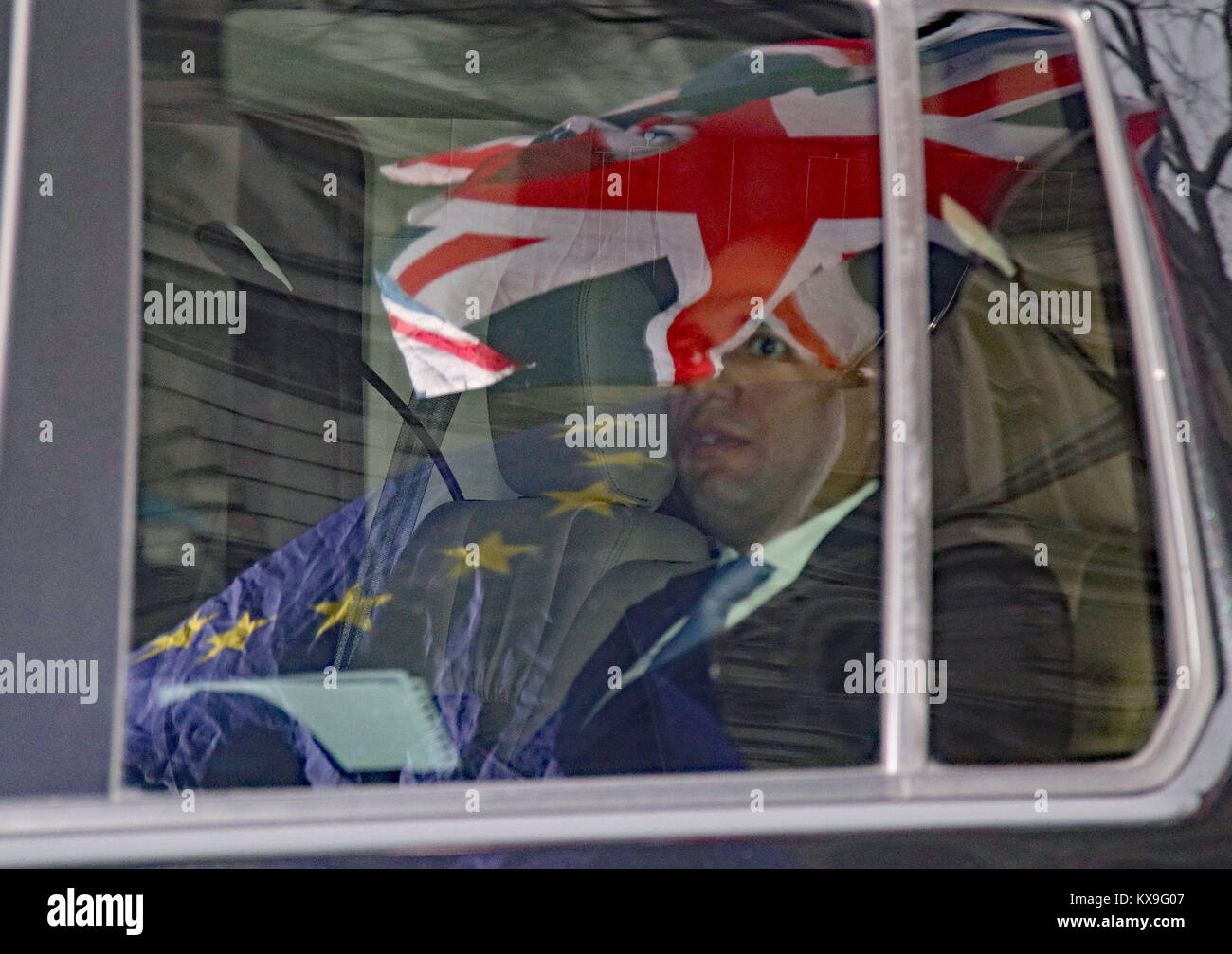 The Union flag and the EU flag are reflected in the window of the car carrying Communities Secretary Sajid Javid as he leaves Downing Street, London, where Theresa May is reshuffling her top team. Stock Photo