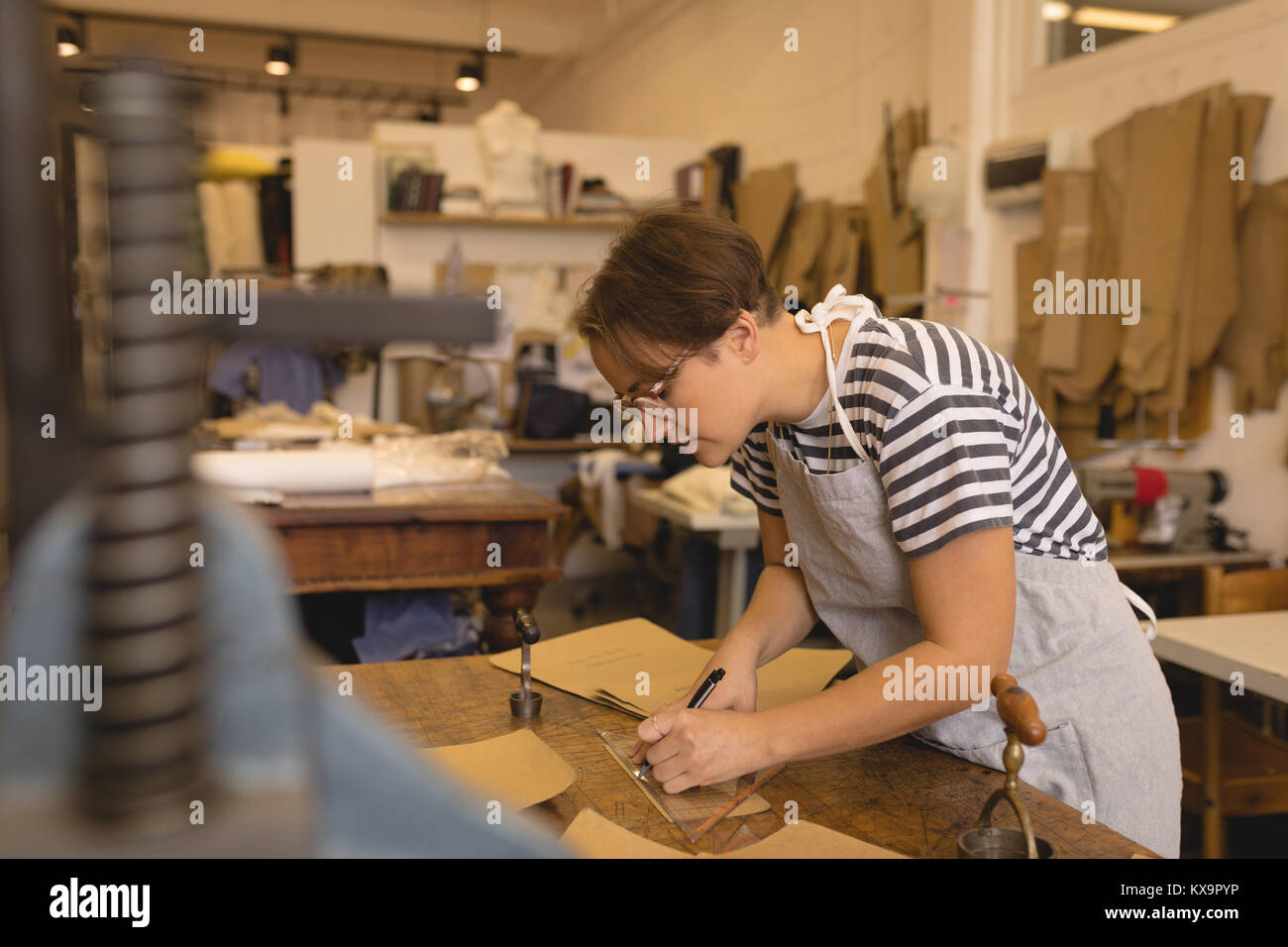 Worker marking on leather in Stock Photo Alamy