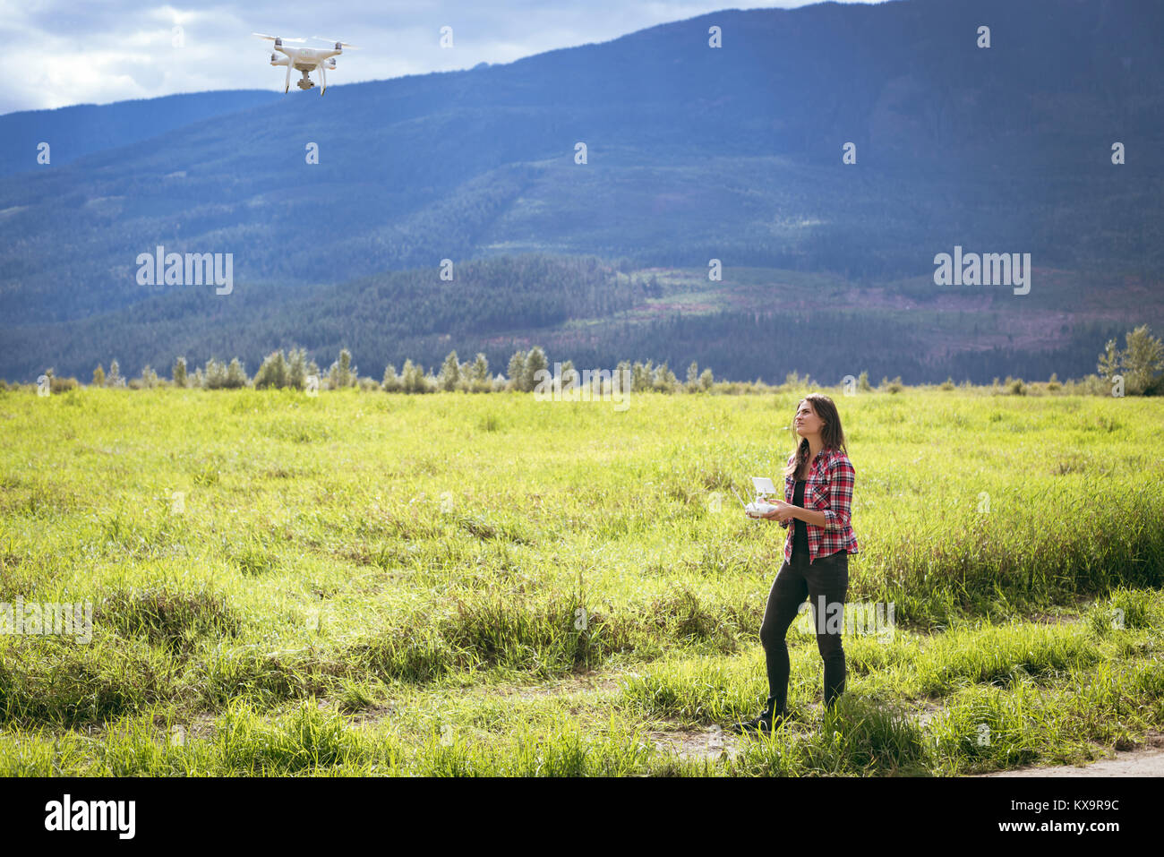 Woman operating drone using a remote control Stock Photo - Alamy