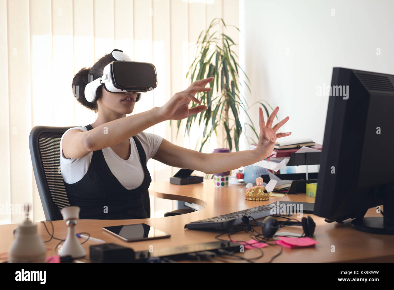 Female executive using virtual reality headset Stock Photo - Alamy