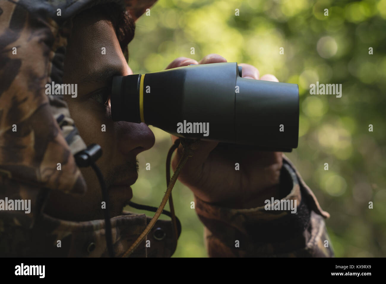 Hunter looking through binoculars in forest Stock Photo Alamy