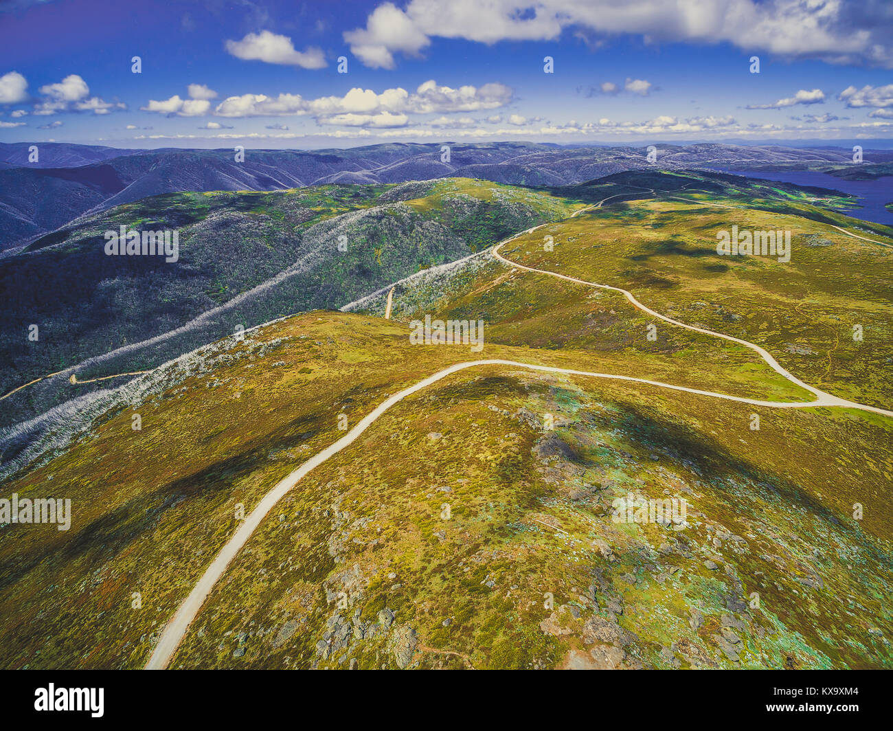 Aerial view of beautiful mountains and winding road on bright sunny day ...