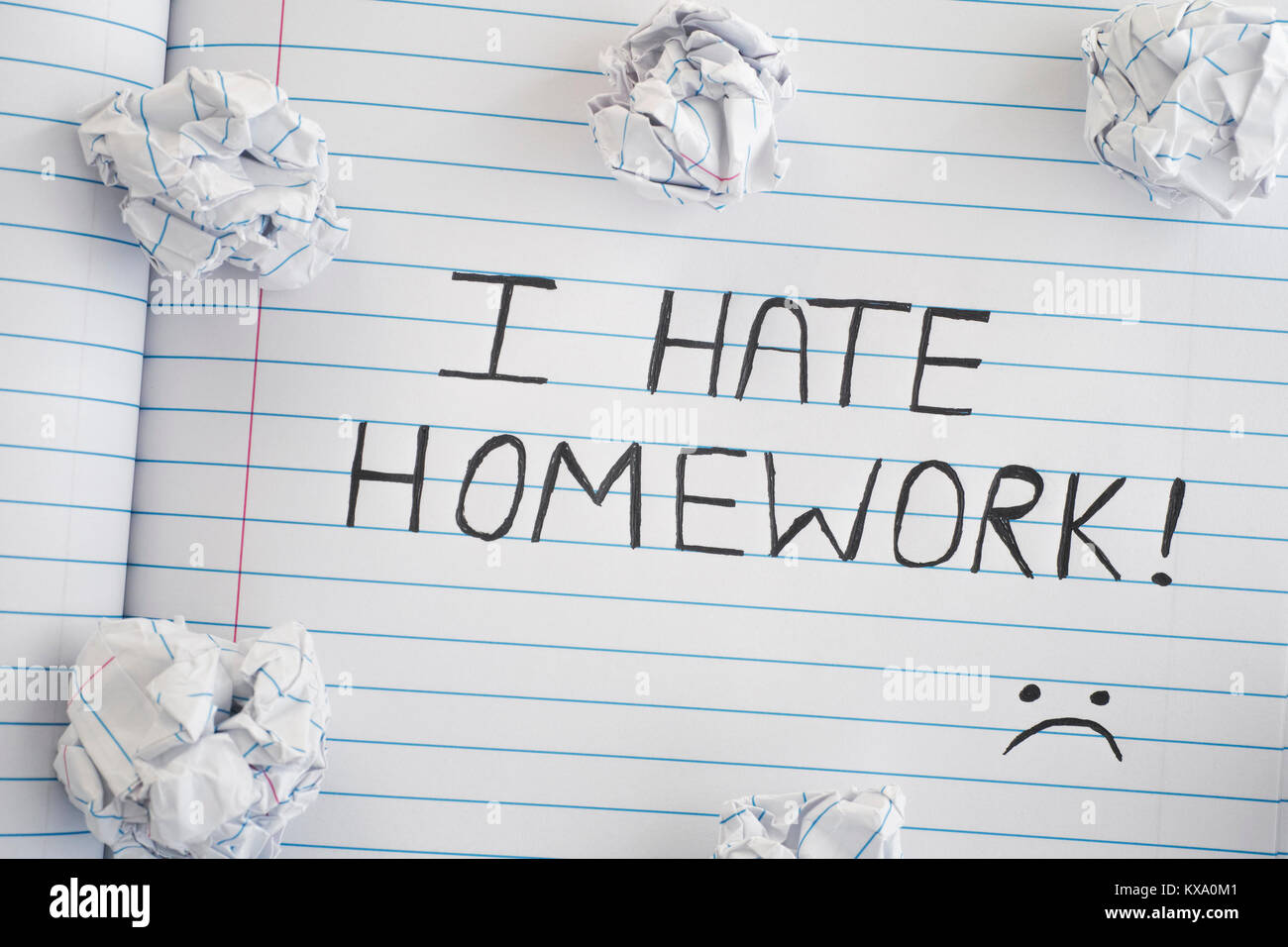 I Hate Homework. Phrase I Hate Homework on notebook sheet with some crumpled paper balls on it. Close up. Stock Photo