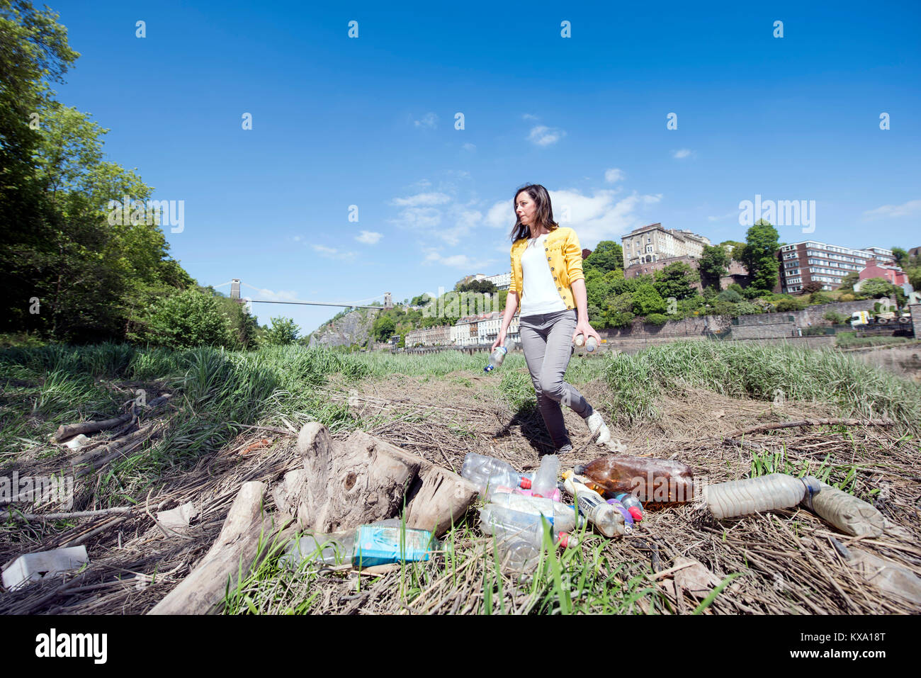 A member of ‘City To Sea’, a campaign to rid Bristol of plastic bottle waste collecting waste bottles on the banks of the Avon, UK Stock Photo