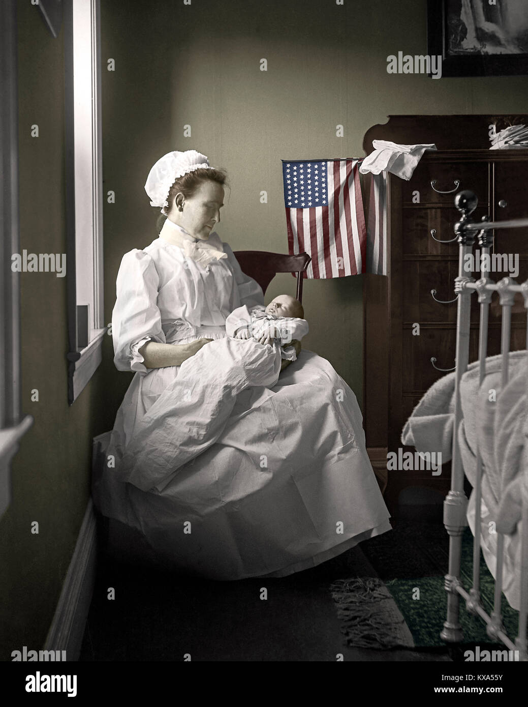 Mother with newborn baby in bedroom. The US Flag with 46 stars was in use from  July  4, 1908 to  July 3, 1912. Image from 4x5 inch B&W nitrate camera negative. Stock Photo